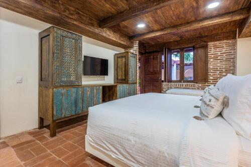 a bedroom with a white bed and a television at Casa D Boutique in Cartagena de Indias