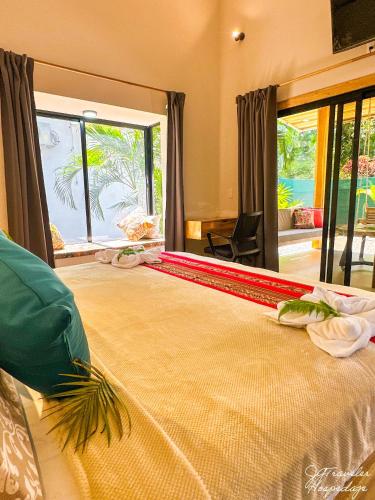 a bedroom with a large bed with a large window at Yiven Natural Village in Puerto Viejo