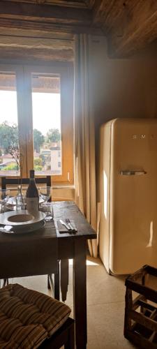 a kitchen with a table and a refrigerator at Eifù - Un antico nido ritrovato in Robecco sul Naviglio