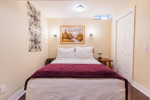 a bedroom with a large bed and a painting on the wall at Richmond Hill Ravine Retreat in Richmond Hill