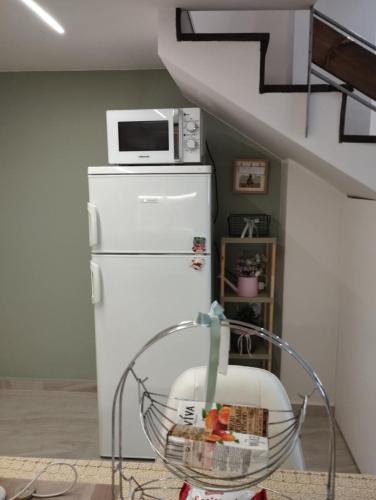 a white refrigerator with a microwave on top of it at MiniLoft apartment in Volos