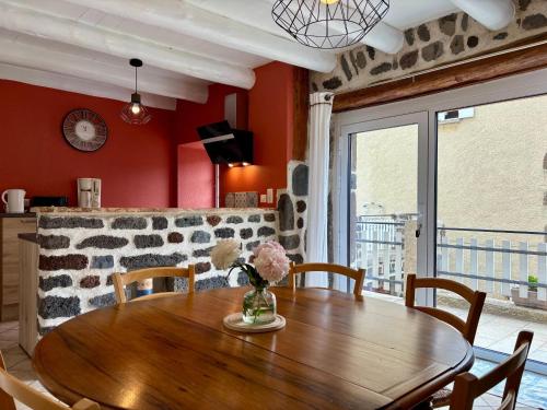 une salle à manger avec une table en bois et des chaises dans l'établissement Gîte tout inclus avec terrasse, jardin et parkings, proche Puy-en-Velay et chemins de randonnée. - FR-1-582-323, à Séneujols
