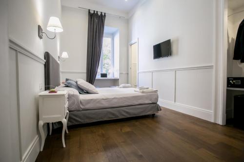 una camera da letto bianca con un letto e una finestra di Relais della Torre a Roma