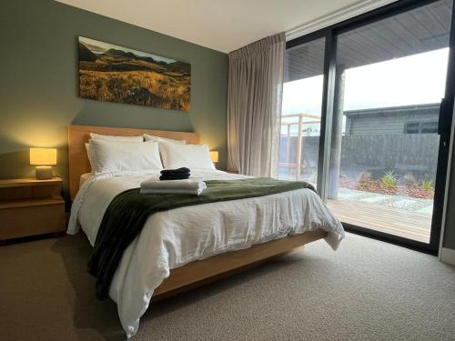 ein Schlafzimmer mit einem Bett und einem großen Fenster in der Unterkunft NEW! The Black Box - 3 Bedroom Sanctuary in Methven