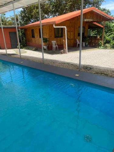 a blue swimming pool in front of a house at Casa de campo Ecos del Poás in Alajuela