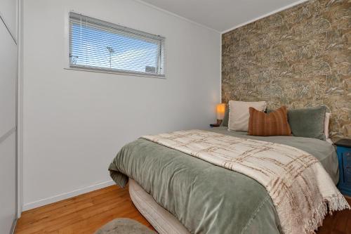 a bedroom with a bed and a window at Matapouri Magic - Matapouri Holiday Home in Matapouri