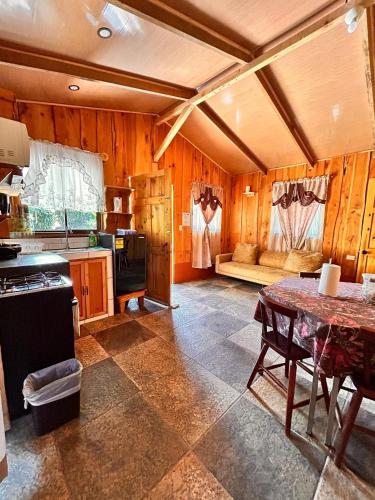 a kitchen with a table and a couch in a room at Casa de campo Ecos del Poás in Alajuela