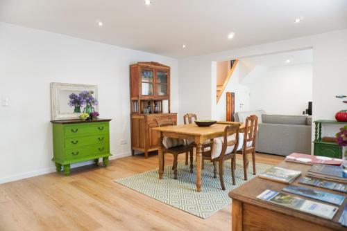 a dining room with a table and a green cabinet at Casa das Amoreiras in Vila Franca do Campo