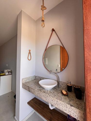 a bathroom with a sink and a mirror on a counter at Barra Grande Flat Manaí in Marau