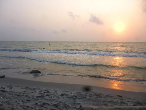a beach with the sun setting over the ocean at Cabaña desde 4 huéspedes 560 metros cuadrados con Naturaleza a 300 metros mar in Necoclí