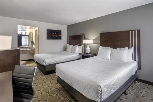 a hotel room with two beds and a chair at Best Western Pahrump Oasis in Pahrump