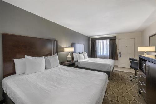 a hotel room with two beds and a television at Best Western Pahrump Oasis in Pahrump