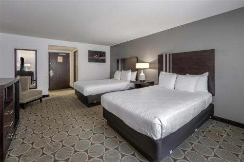 a hotel room with two beds and a television at Best Western Pahrump Oasis in Pahrump