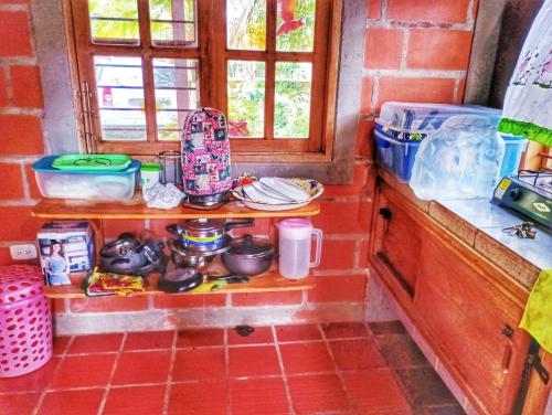 a kitchen with a shelf with pots and pans at Cabaña desde 4 huéspedes 560 metros cuadrados con Naturaleza a 300 metros mar in Necoclí