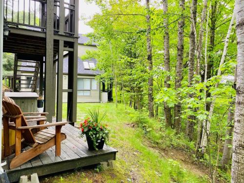 a porch of a house with a bench and flowers at Le Tiny loft ski in ski out in Mont-Tremblant