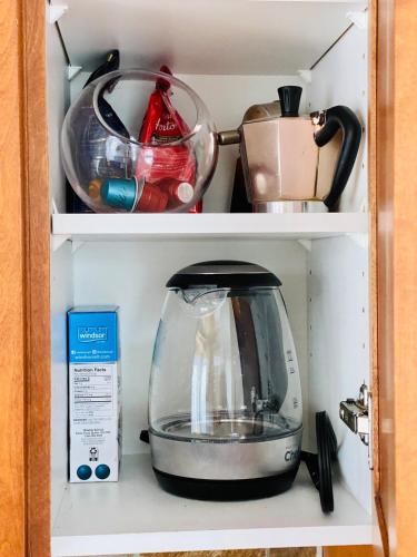 a coffee maker is sitting on a shelf in a cupboard at Le Tiny loft ski in ski out in Mont-Tremblant