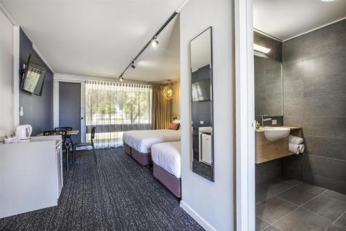 a hotel room with a bed and a bathroom at Nightcap at Gateway Hotel in Corio