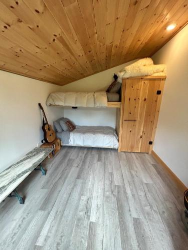 a room with two bunk beds and a guitar at Sunny 2BR with Pond, Fireplace, Walk to Stowe in Stowe