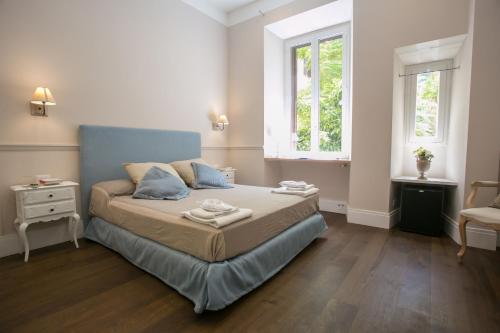 una piccola camera da letto con un letto e due finestre di Relais della Torre a Roma