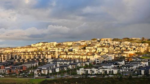 a group of houses on top of a hill at Sunrise to Sunset Coastal Escape B&B in Auckland