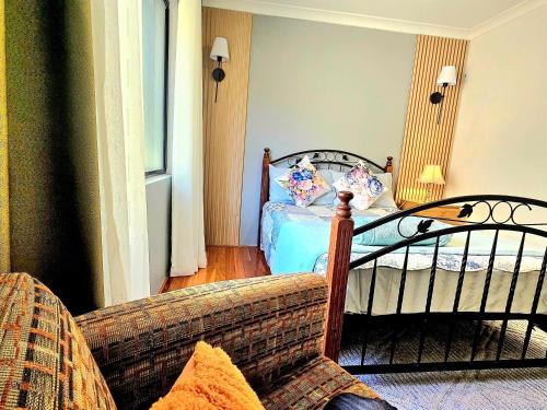 a living room with a bed and a couch at Joyful Living Guest House in Coogee
