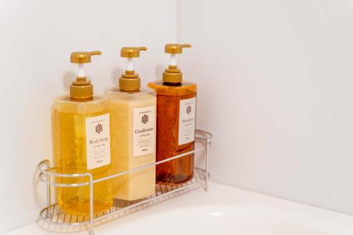 four bottles of oils in a rack on a shelf at PLAY!! Resi Stay in Kyoto