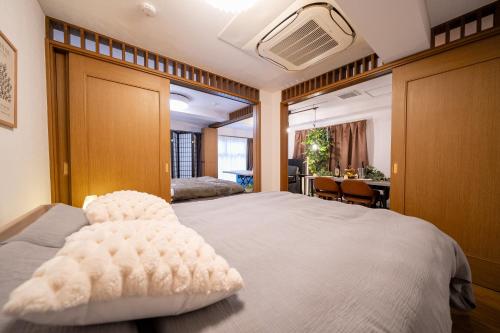 a bedroom with a large bed and a table at THE MULTIPLE Shinjuku WEST in Tokyo