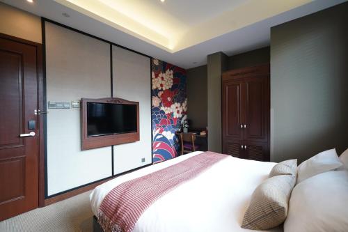 a bedroom with a bed and a flat screen tv at STORIES Joo Chiat, a Hotel by Cove - Paya Lebar, Singapore - NEWLY RENOVATED in Singapore