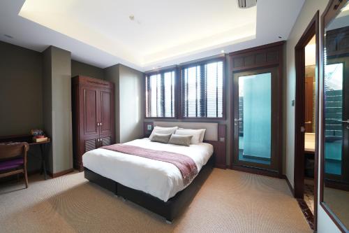 a bedroom with a large bed and a window at STORIES Joo Chiat, a Hotel by Cove - Paya Lebar, Singapore - NEWLY RENOVATED in Singapore