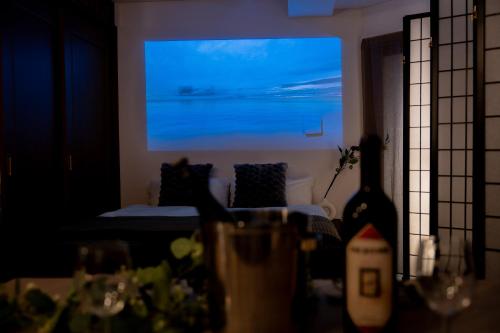a living room with a bed and a large screen at THE MULTIPLE Shinjuku WEST in Tokyo