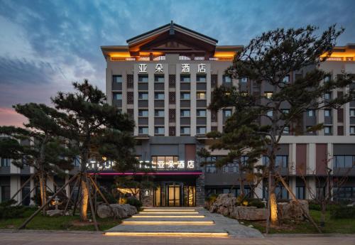 a rendering of a hotel at dusk at Atour Hotel Jinan Jingshidong Road Rongchuangmao in Jinan