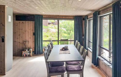 a dining room with a table and chairs and windows at Beautiful Home In Dølemo in Austenå