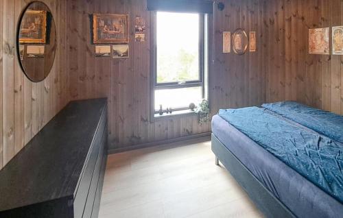 a bedroom with a bed and a mirror and a window at Beautiful Home In Dølemo in Austenå