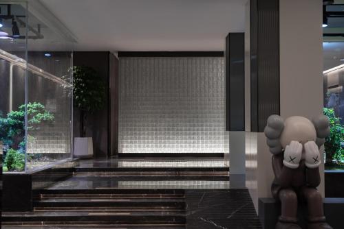 a lobby of a building with stairs and a statue at Atour Hotel Jinan Jingshidong Road Rongchuangmao in Jinan