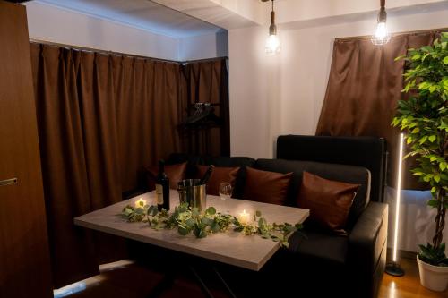 a living room with a couch and a table with candles at THE MULTIPLE Shinjuku WEST in Tokyo