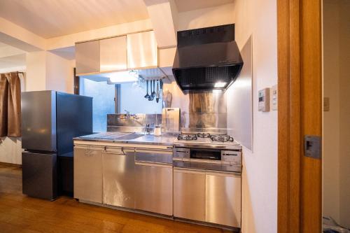 a kitchen with a stove and a refrigerator at THE MULTIPLE Shinjuku WEST in Tokyo