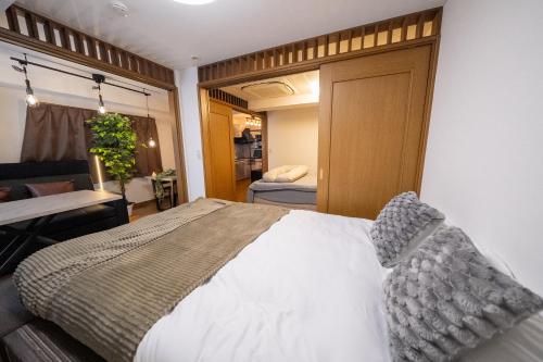 a bedroom with a large bed and a bathroom at THE MULTIPLE Shinjuku WEST in Tokyo