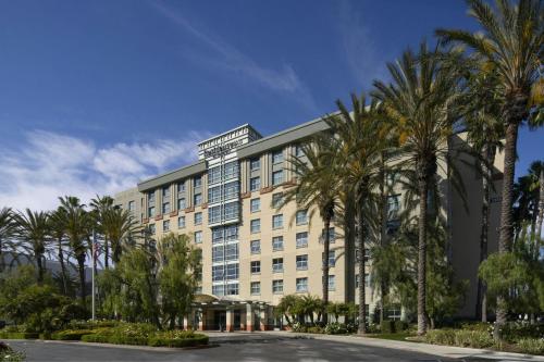 a large building with palm trees in front of it at Residence Inn Irvine John Wayne Airport Orange County in Irvine