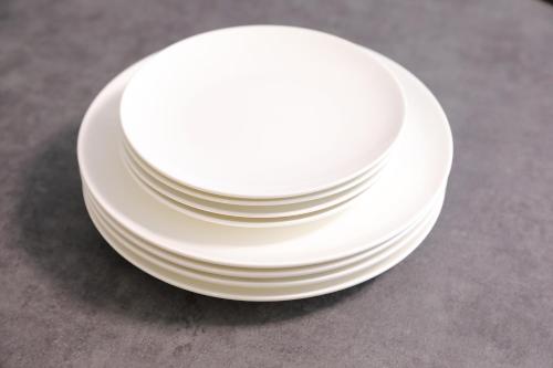 a stack of white plates sitting on a table at シティラデファンス - 2025年6月室内リニューアル in Sapporo