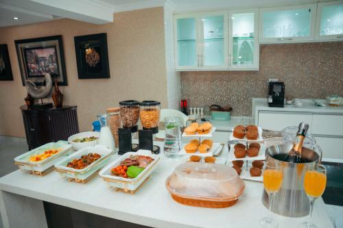 a kitchen counter with many dishes of food and drinks at Escapade Lux Guesthouse in Gaborone