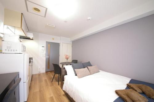 a bedroom with a white bed and a table at シティラデファンス - 2025年6月室内リニューアル in Sapporo