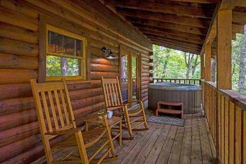a porch of a cabin with two chairs and a hot tub at Location Log Cabin Hot Tub Fireplace Pool Fishing in Pigeon Forge