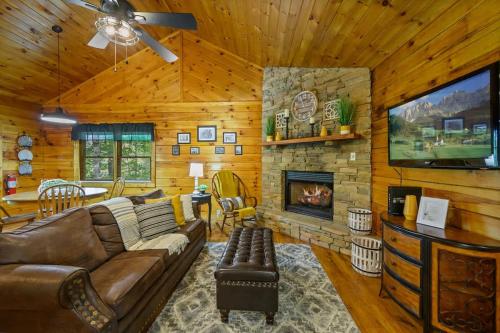 a living room with a couch and a fireplace at Location Log Cabin Hot Tub Fireplace Pool Fishing in Pigeon Forge