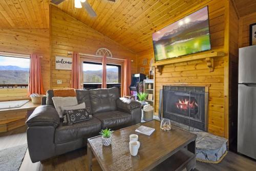 a living room with a couch and a fireplace at Great View Location Studio Log Cabin Hot Tub in Gatlinburg