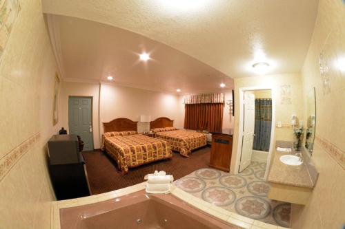 a hotel room with two beds and a bath tub at The Palace Inn in Oxnard