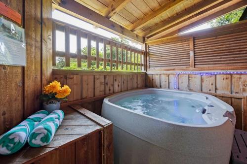 a bathroom with a tub in a wooden house at Location Smokies Log Cabin Hot Tub Fireplace in Pigeon Forge