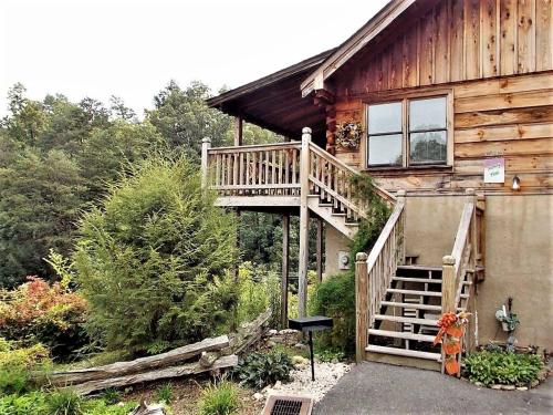 a wooden house with a staircase leading up to it at Location Smokies Log Cabin Hot Tub Fireplace in Pigeon Forge