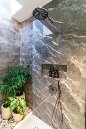 a shower in a bathroom with plants at Jago Gili Air in Gili Islands
