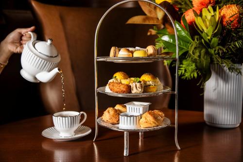 a three tiered tray with pastries and a cup of tea at Rydges South Bank Brisbane in Brisbane