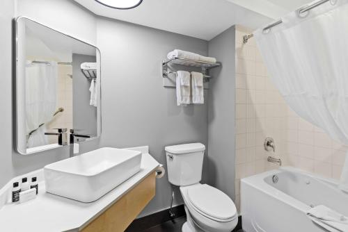 a white bathroom with a sink and a toilet at Hotel Feng, BW Signature Collection in Parksville